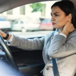Driver holding her neck with delayed symptoms after a car accident