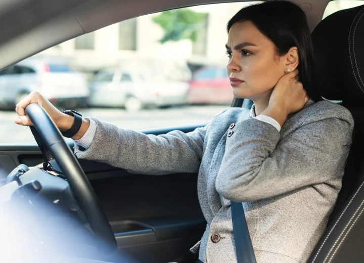 Driver holding her neck with delayed symptoms after a car accident